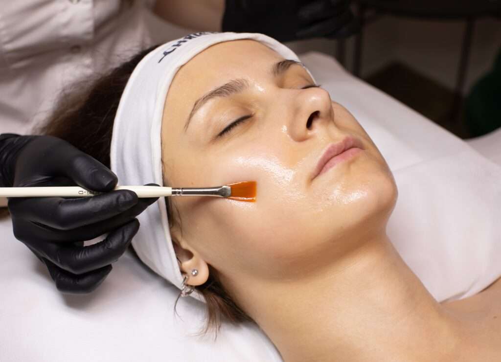 Corinne applying a SkinCeuticals chemical peel treatment to a client for radiant, even-toned skin